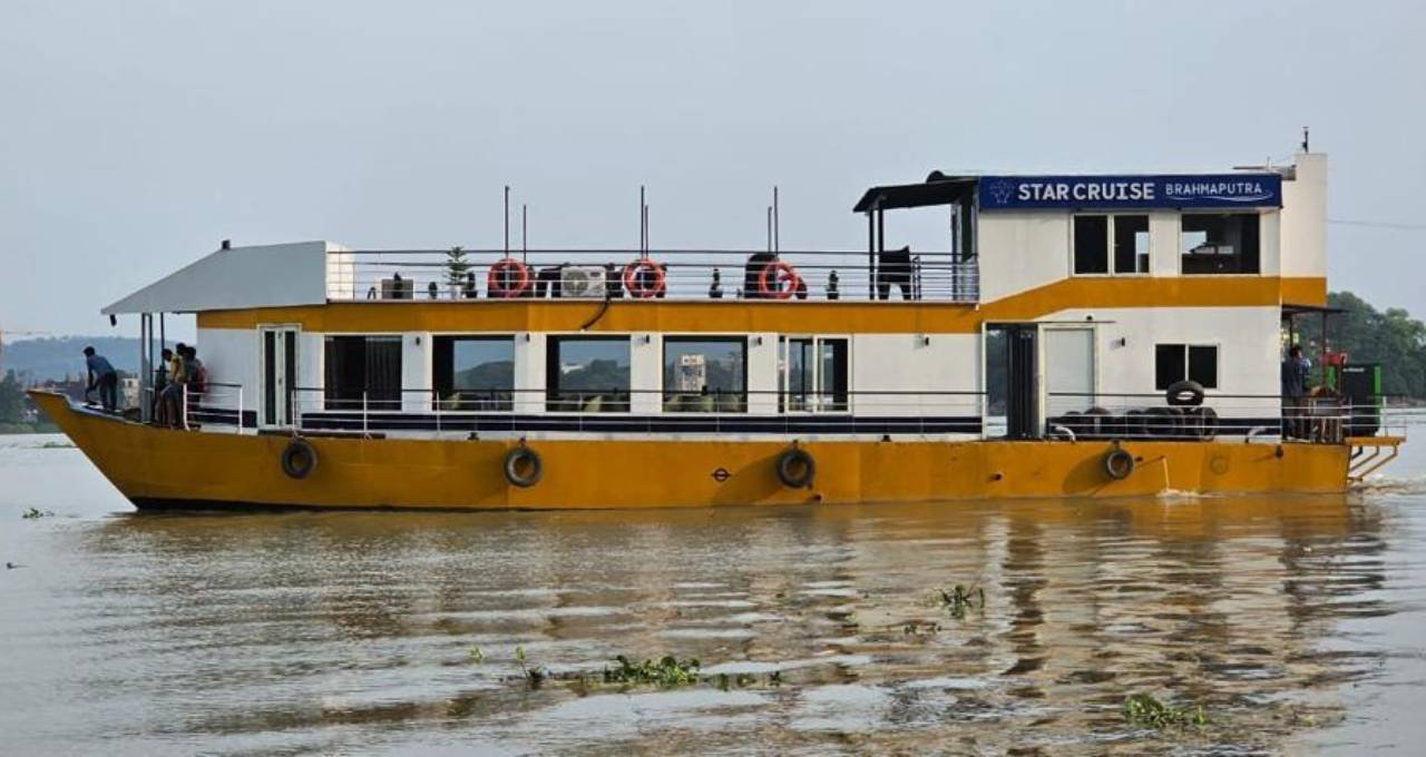 Star Cruise under way on the Brahmaputra, her yellow and white hull carrying the name Star Cruise Brahmaputra along the side.