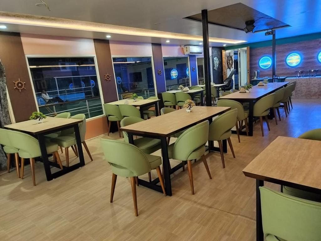 Wide view along the saloon towards the serving counter at the far end, showing the full run of seating.